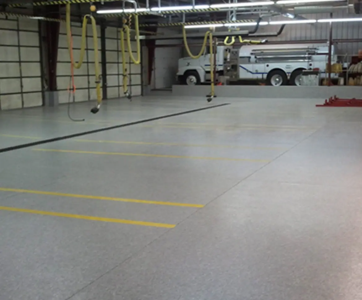 High-gloss polished concrete warehouse floor with yellow safety stripe markings
